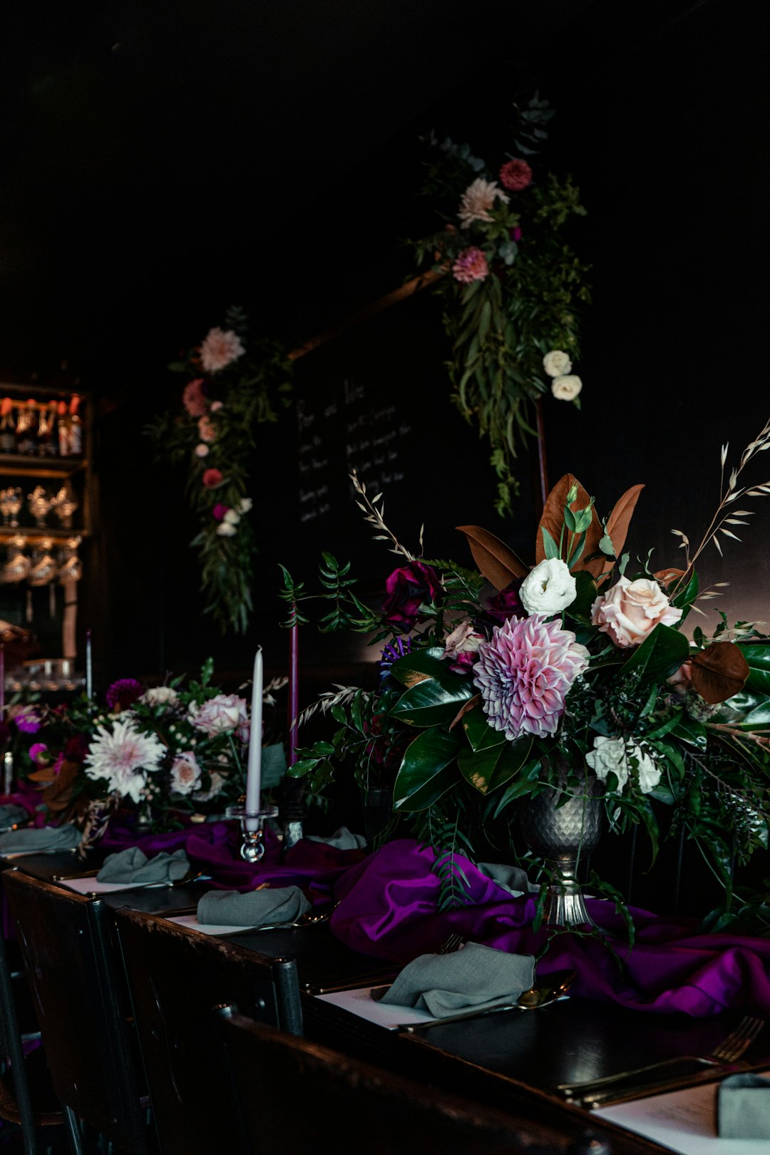 a-long-table-with-purple-and-white-flowers-on-it-lmx02vepr4